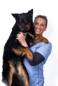 Dyrlæge Ninna Verland med stor schæferhund i armene